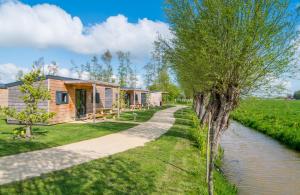 a row of cottages next to a river at Familie Resort Molenwaard in Ottoland