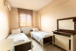 Habitación hospitalaria con 2 camas y TV en Beyoglu Huzur Hotel, en Estambul