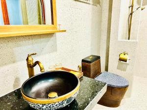 a bathroom with a sink with a gold faucet at Rova Hotel Phú Quốc in Phú Quốc