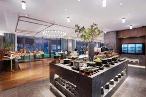 a restaurant with a counter with pots and pans at S&N Yiting Hotel Taizhou in Taizhou