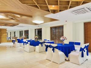 um salão de banquetes com mesas azuis e cadeiras brancas em SJ PARADISE em Dehradun
