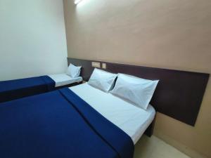 a bed with two pillows on it in a room at Royal Residency in Kumbakonam