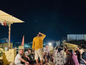 Un homme debout devant une foule de gens dans l'établissement Sagar Guest House, à Jaisalmer