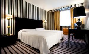 1 dormitorio con 1 cama blanca grande y escritorio en Hotel Clarin, en Oviedo