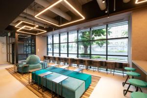 a conference room with a table and chairs and windows at Prince Smart Inn Naha in Naha