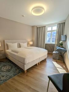 a bedroom with a large white bed and a window at Hotel Martin am Dom in Bamberg