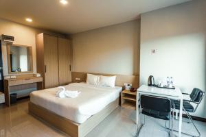 a hotel room with a bed and a desk and a mirror at AT Apartment in Hat Yai