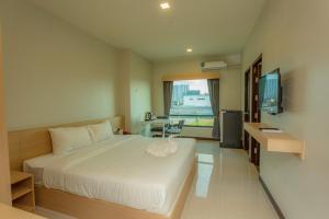 a hotel room with a bed and a television at AT Apartment in Hat Yai