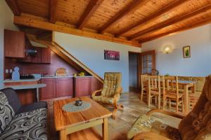 ein Wohnzimmer mit einem Tisch und einer Küche in der Unterkunft Willa Radosna in Rudzica