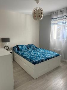 Un dormitorio con una cama con sábanas azules y una lámpara de araña. en Belle Maison MALOU calme, SPA jaccuzzi 3km plage Labenne, en Labenne