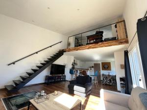 ein Wohnzimmer mit einer Treppe und einer Couch in der Unterkunft Superbe Loft, dégustations vignoble familial in Villars-en-Pons