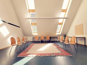 une pièce vide avec des chaises et un tapis au sol dans l'établissement Europäisches Gäste- und Seminarhaus, à Todtmoos