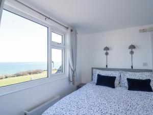 um quarto com uma cama e uma grande janela em Sea View em Mevagissey
