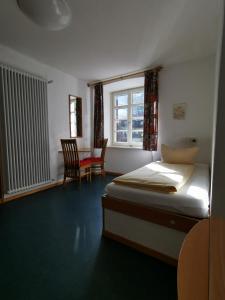 um quarto com uma cama, uma mesa e cadeiras em Europäisches Gäste- und Seminarhaus em Todtmoos