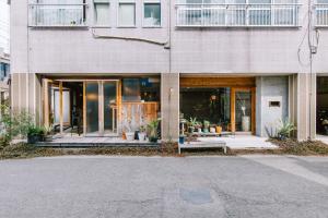 ein Backsteingebäude mit Glastüren und einer Veranda in der Unterkunft Guesthouse RICO in Wakayama