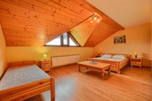 um quarto no sótão com 2 camas e uma mesa em Willa Radosna em Rudzica