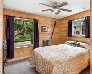 1 dormitorio con 1 cama y ventilador de techo en Swan Lake Resort & Campground, en Fergus Falls