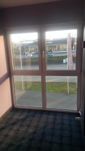 um quarto vazio com duas grandes portas de vidro deslizantes em SleepySleepy Hotel Gießen em Giessen