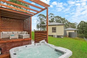 a hot tub on a deck with a house at Blueberry Hills On Comleroy Farmstay - Self-Contained Cottages in Kurrajong