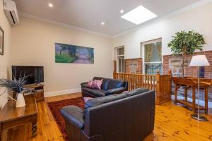 a living room with a couch and a television at Tanunda Central Cottage in Tanunda