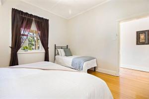 a bedroom with two beds and a window at Tanunda Central Cottage in Tanunda