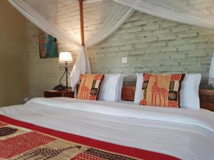 sypialnia z białym łóżkiem z poduszkami w obiekcie Zaburi Beach by Serendib w mieście Mangochi