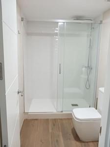 a white bathroom with a shower and a toilet at Apartamento Central D in Algeciras