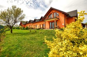 una casa arancione su un campo verde con un cortile di Willa Radosna a Rudzica