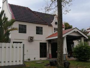 une maison blanche avec une clôture blanche et un arbre dans l'établissement Hilal Sofia 933villa dfaro, Afamosa Resort Malacca, à Kampong Alor Gajah