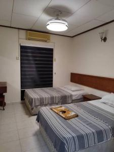 Cette chambre comprend deux lits et une grande fenêtre. dans l'établissement Hilal Sofia 933villa dfaro, Afamosa Resort Malacca, à Kampong Alor Gajah