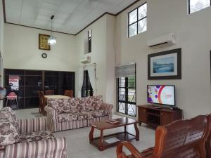 - un salon avec deux canapés et une télévision dans l'établissement Hilal Sofia 933villa dfaro, Afamosa Resort Malacca, à Kampong Alor Gajah