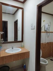 La salle de bains est pourvue d'un lavabo, de toilettes et d'un miroir. dans l'établissement Hilal Sofia 933villa dfaro, Afamosa Resort Malacca, à Kampong Alor Gajah