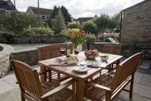 a wooden table and chairs on a patio at The Cottage Harmby in Spennithorne