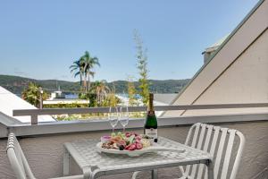 un tavolo con un piatto di cibo e una bottiglia di vino di Sunchaser at Iluka Resort Apartments a Palm Beach