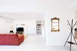 uma sala de estar com um sofá vermelho e uma TV em Comfort Sunny Hub with 2 bdr em Atenas