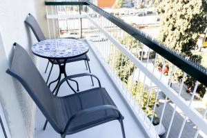 a table and chairs sitting on a balcony at Comfort Sunny Hub with 2 bdr in Athens
