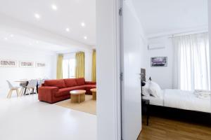 salon z czerwoną kanapą i łóżkiem w obiekcie Comfort Sunny Hub with 2 bdr w Atenach