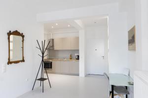 uma cozinha branca com uma mesa e um espelho em Comfort Sunny Hub with 2 bdr em Atenas