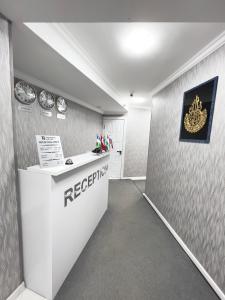 an office with a reception desk and clocks on the wall at Tashkent Hotel in Yakkasaray