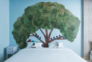 a tree with birds sitting on top of a bed at Beat Hotel Bangkok in Bangkok