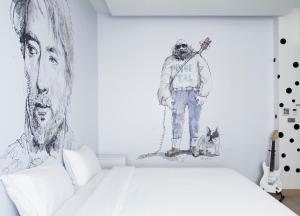 a bedroom with a bed and a picture of a man at Beat Hotel Bangkok in Bangkok
