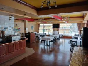 a restaurant with tables and chairs in a room at Lakeview Inns & Suites - Hinton in Hinton