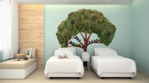 a room with three beds and a tree on the wall at Beat Hotel Bangkok in Bangkok