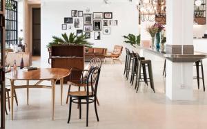 a dining room with chairs and a table and a bar at Beat Hotel Bangkok in Bangkok