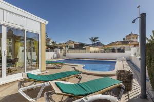 a patio with two lounge chairs and a swimming pool at Villa Herrero in Mazarrón