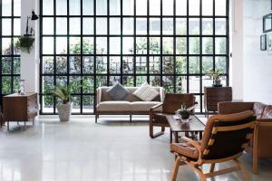 a living room with a couch and chairs and large windows at Beat Hotel Bangkok in Bangkok