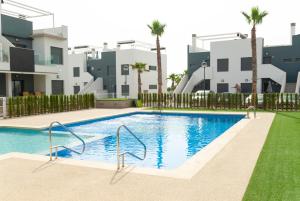 basen przed budynkiem z palmami w obiekcie 3058 Residence Lamar 3058 w mieście Pilar de la Horadada