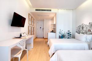 a hotel room with two beds and a desk at Beat Hotel Bangkok in Bangkok