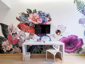 a desk in a room with a flower mural on the wall at Beat Hotel Bangkok in Bangkok
