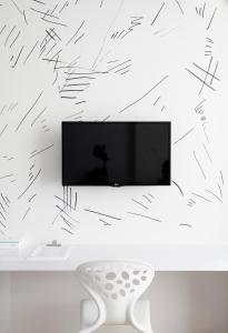 a living room with a tv and a white chair at Beat Hotel Bangkok in Bangkok